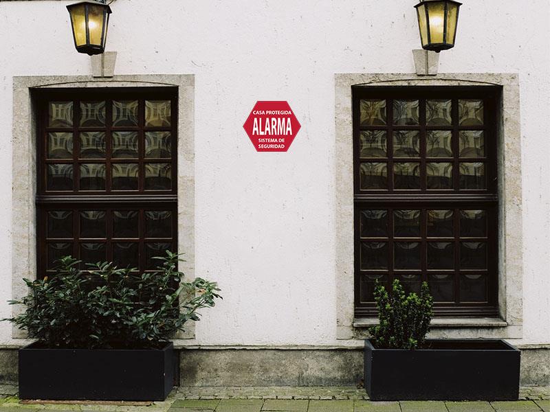 fachada de casa con letrero de alarma